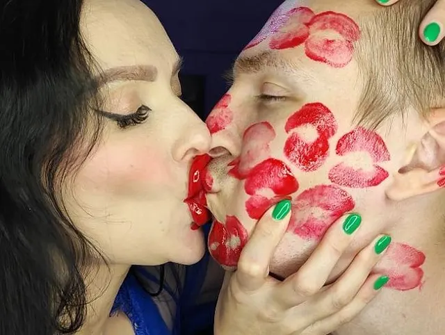Klebrige, saftige rote Lippenstiftküsse auf seinem ganzen Gesicht