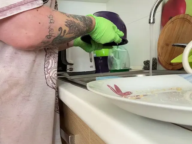 Geschirrspülen mit grünen Handschuhen