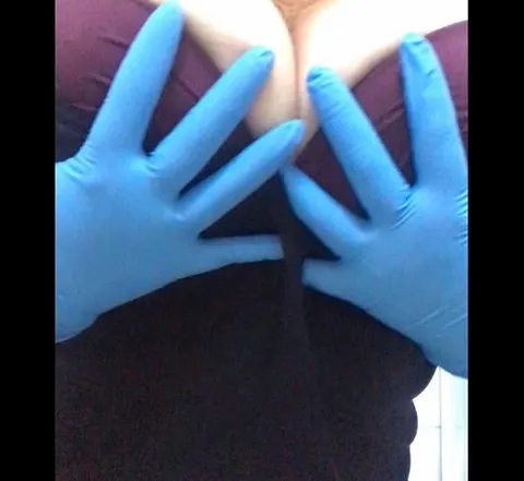 Krankenschwester zieht Latexhandschuhe an.