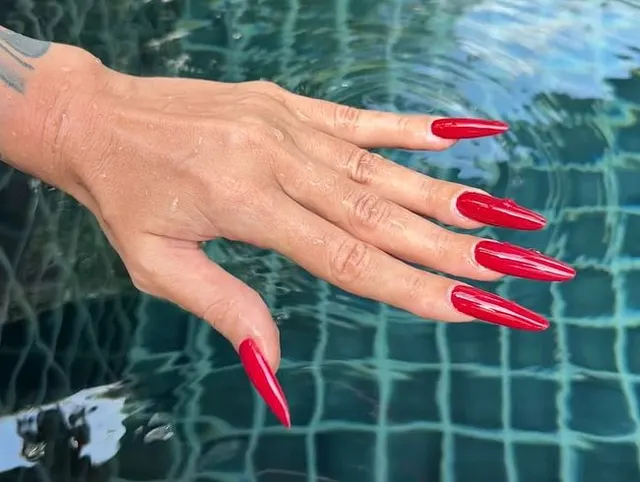Lange ROTE Nägel und lange Finger im Schwimmbad